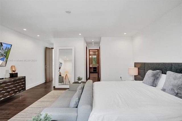 bedroom with baseboards, ensuite bathroom, recessed lighting, and wood finished floors