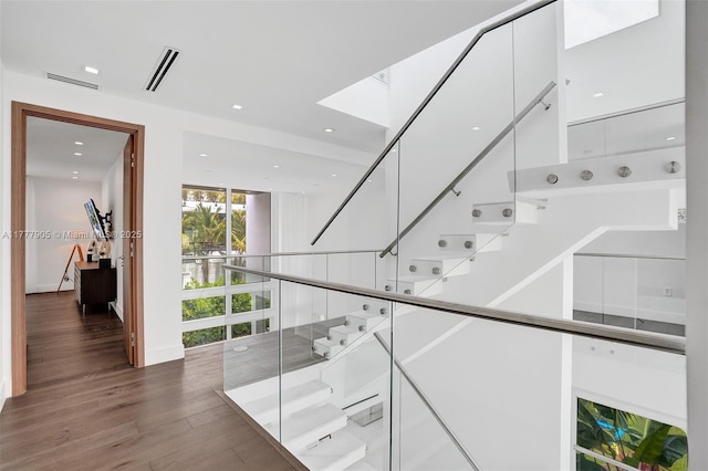 stairway with recessed lighting, visible vents, and wood finished floors