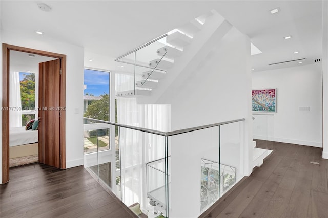 corridor with recessed lighting, hardwood / wood-style flooring, and stairs