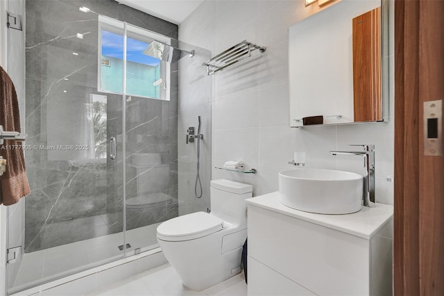 full bath with toilet, tile walls, a shower stall, and vanity