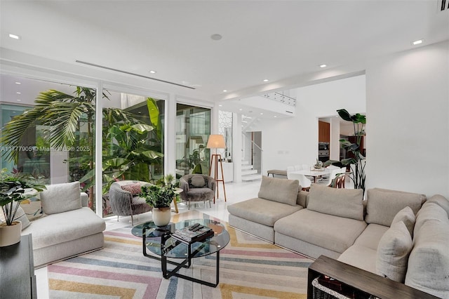 living area with recessed lighting, stairway, and a wall of windows