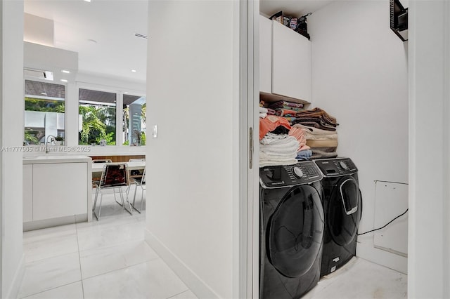 clothes washing area with recessed lighting, a sink, and washer and clothes dryer