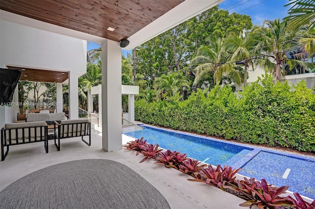 view of swimming pool with an outdoor living space, a patio area, and a fenced in pool