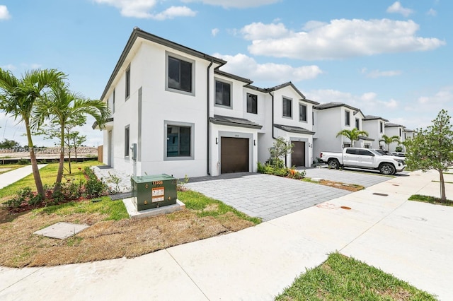 18918 SW 345th Ter, Homestead, FL 33034 - view of front of home with an attached garage, decorative driveway, stucco siding, and a residential view