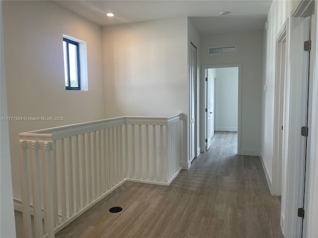 corridor featuring an upstairs landing, recessed lighting, baseboards, visible vents, and wood finished floors