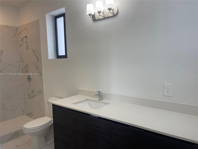 full bath with marble finish floor, a tile shower, toilet, and vanity