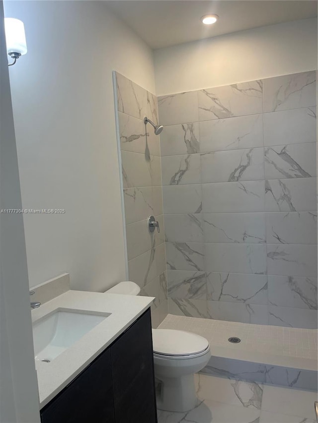 full bathroom with marble finish floor, toilet, a stall shower, and vanity