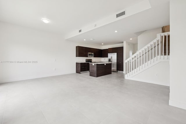 18918 SW 345th Ter, Homestead, FL 33034 - unfurnished living room featuring stairs, recessed lighting, light tile patterned floors, and baseboards