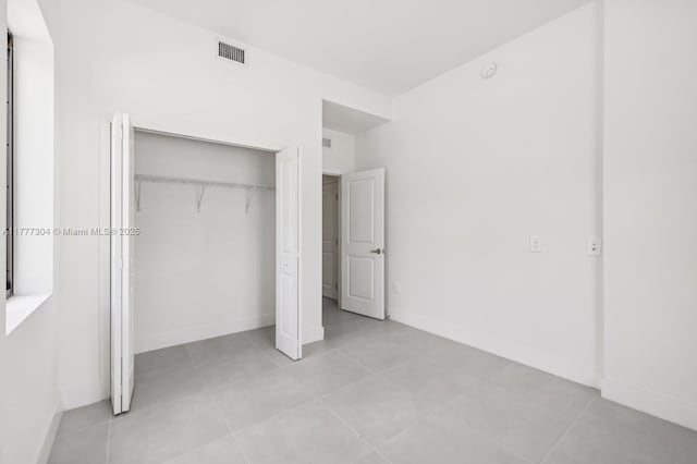 18918 SW 345th Ter, Homestead, FL 33034 - unfurnished bedroom featuring a closet, baseboards, and light tile patterned flooring