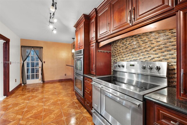 4340 NW 6th St, Plantation, FL 33317 - kitchen with light tile patterned floors, stainless steel appliances, under cabinet range hood, baseboards, and decorative backsplash