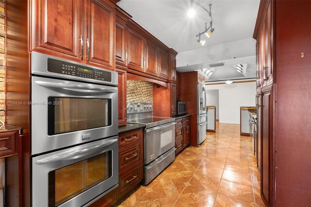 4340 NW 6th St, Plantation, FL 33317 - kitchen featuring baseboards, backsplash, dark countertops, reddish brown cabinets, and appliances with stainless steel finishes