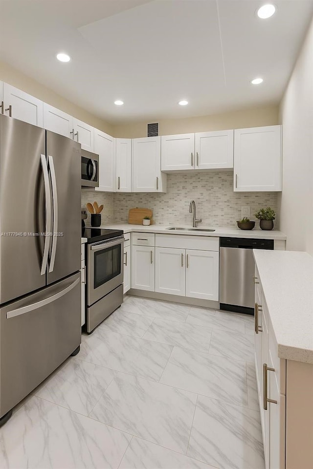 13250 SW 4th Ct Unit 405G, Pembroke Pines, FL 33027 - kitchen featuring appliances with stainless steel finishes, light countertops, white cabinets, light marble finish flooring, and decorative backsplash