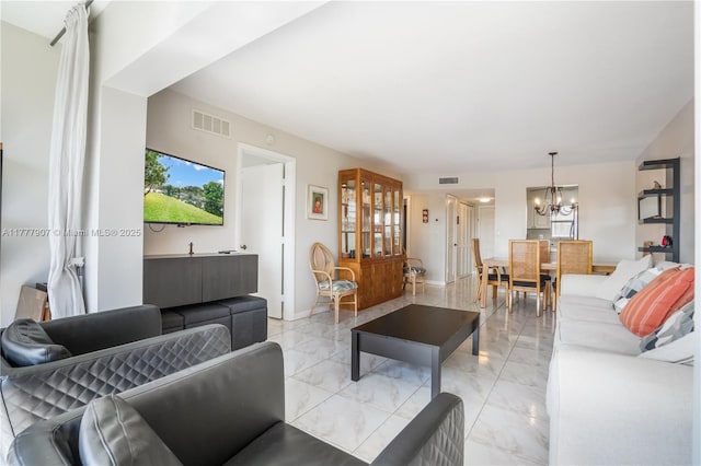 living area with marble finish floor, visible vents, and an inviting chandelier