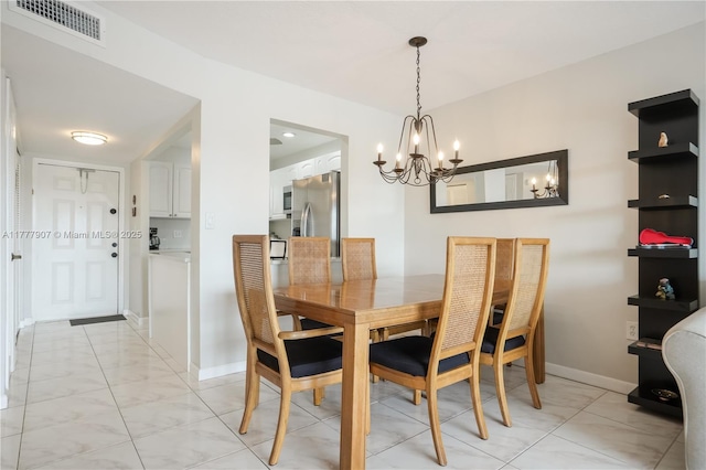dining space featuring baseboards, visible vents, and an inviting chandelier