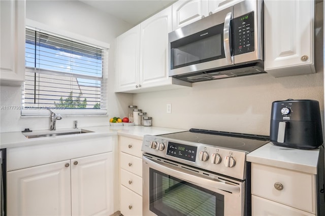 kitchen featuring white cabinetry, light countertops, a sink, and stainless steel appliances