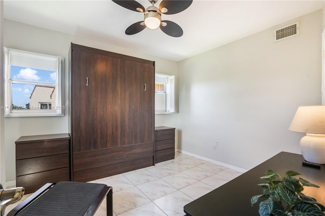 bedroom featuring baseboards, ceiling fan, visible vents, and multiple windows
