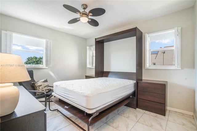 bedroom featuring baseboards, marble finish floor, and a ceiling fan