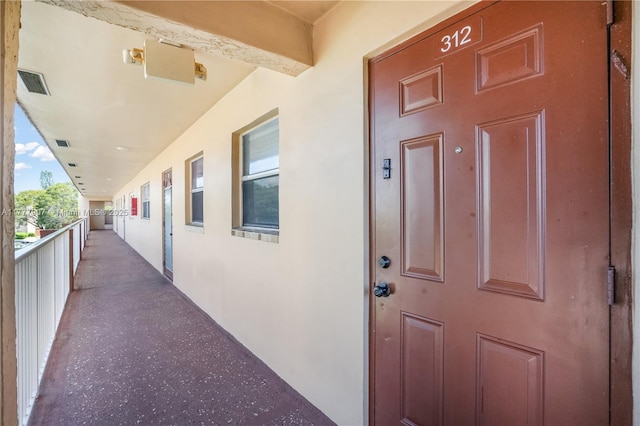 view of exterior entry with stucco siding and visible vents