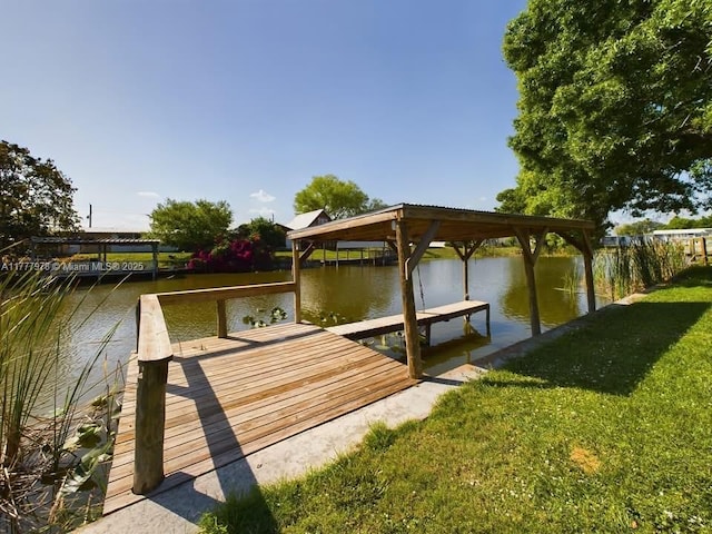 dock area with a lawn, boat lift, and a water view