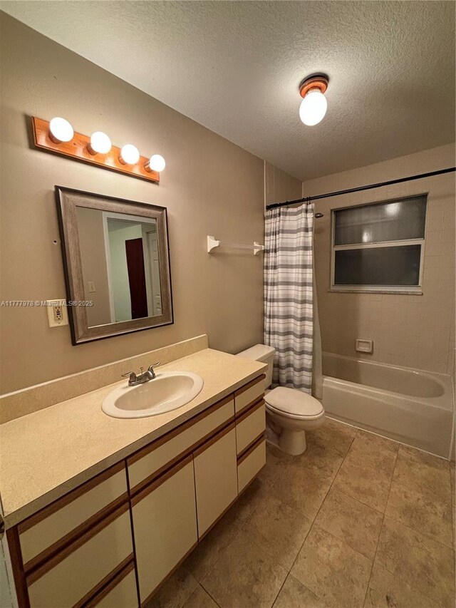 full bath featuring a textured ceiling, vanity, shower / tub combo with curtain, toilet, and tile patterned flooring