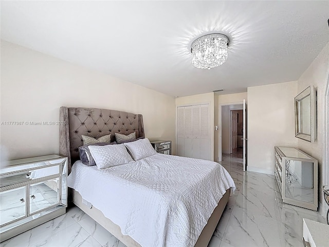 bedroom featuring a closet, marble finish floor, and a notable chandelier