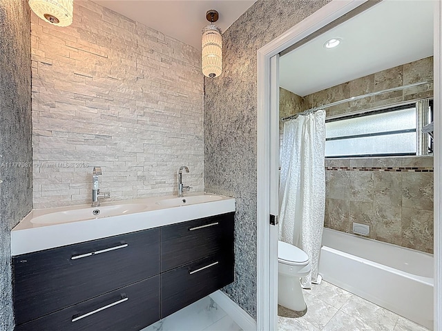 full bath with a sink, toilet, double vanity, and marble finish floor