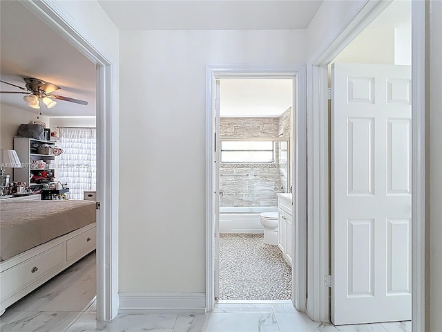 bathroom featuring plenty of natural light, marble finish floor, toilet, and ceiling fan