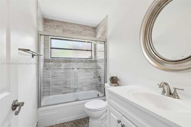 full bathroom featuring toilet, vanity, and enclosed tub / shower combo