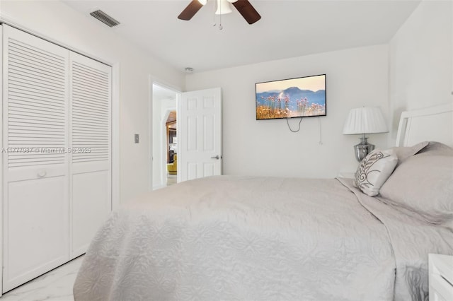 bedroom with marble finish floor, visible vents, a closet, and ceiling fan