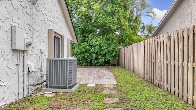 view of yard with a patio, central AC unit, and a fenced backyard