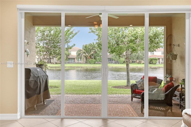 entryway featuring a water view, tile patterned flooring, and ceiling fan