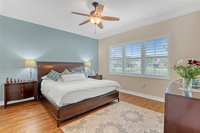 bedroom with ceiling fan, baseboards, crown molding, and wood finished floors