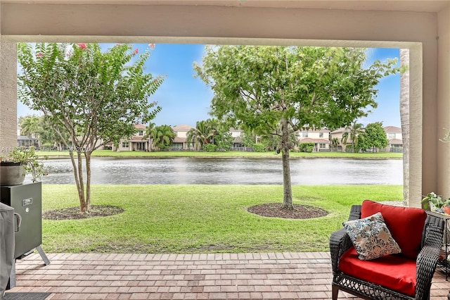 view of patio / terrace with a residential view and a water view