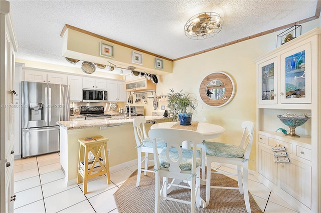 11861 SW 13th Ct, Davie, FL 33325 - kitchen featuring appliances with stainless steel finishes, a textured ceiling, light tile patterned floors, light stone counters, and ornamental molding