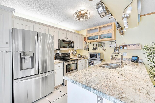 11861 SW 13th Ct, Davie, FL 33325 - kitchen with stainless steel appliances, a sink, a peninsula, a textured ceiling, and light tile patterned floors