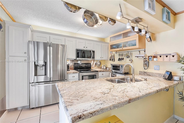 11861 SW 13th Ct, Davie, FL 33325 - kitchen with stainless steel appliances, a peninsula, a sink, a textured ceiling, and light tile patterned flooring