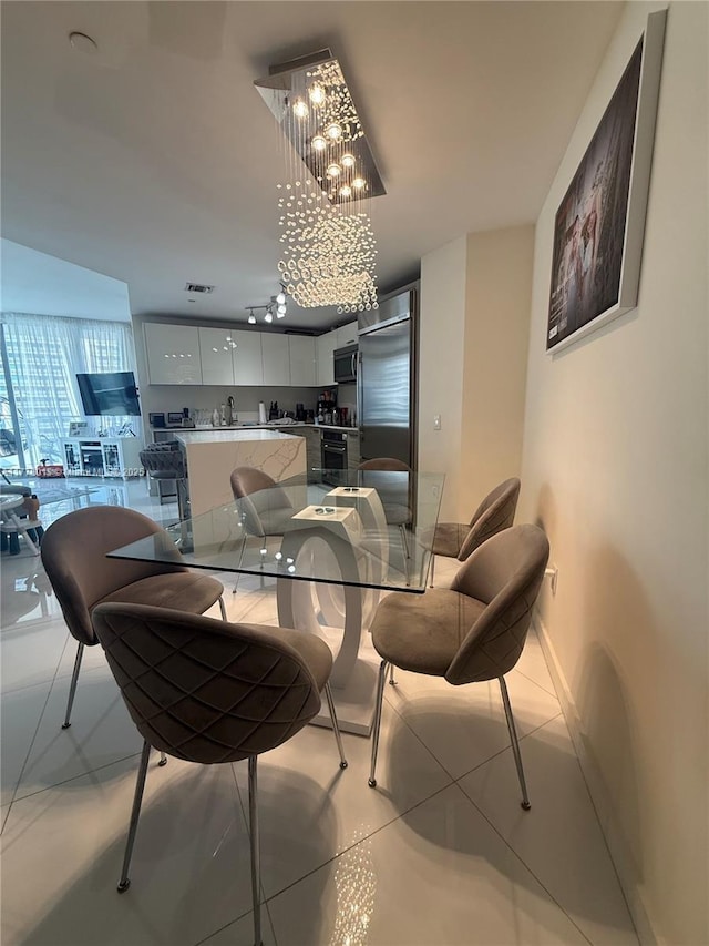 dining space featuring visible vents, baseboards, light tile patterned floors, and a chandelier