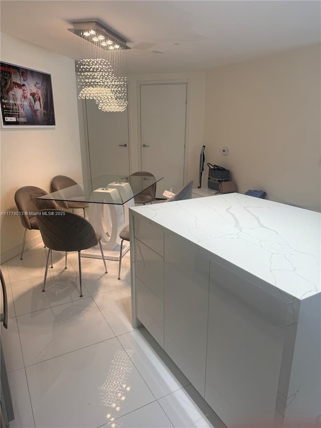 laundry room featuring light tile patterned floors and a chandelier