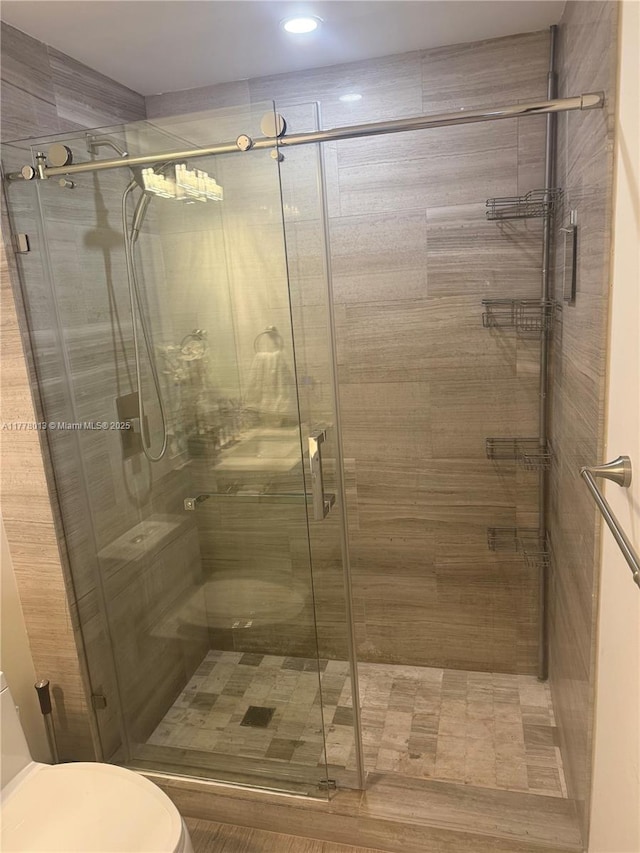 bathroom with recessed lighting, a stall shower, and toilet