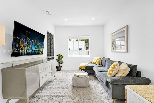living room with baseboards, visible vents, and recessed lighting