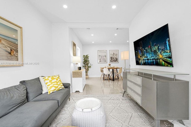 living area with baseboards, marble finish floor, and recessed lighting