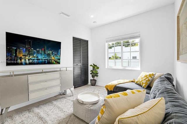 living area featuring baseboards and visible vents