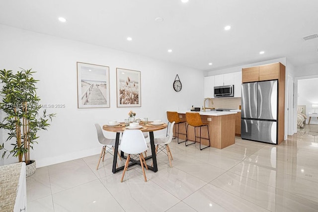 dining area featuring baseboards, visible vents, and recessed lighting