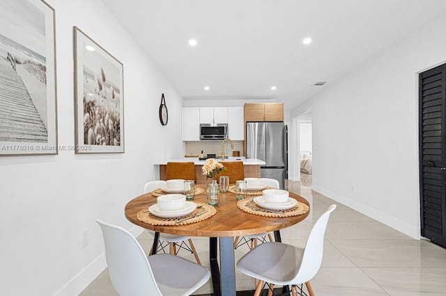 dining space featuring baseboards, visible vents, and recessed lighting