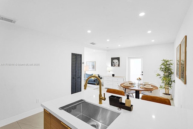kitchen featuring visible vents, light countertops, a sink, and recessed lighting
