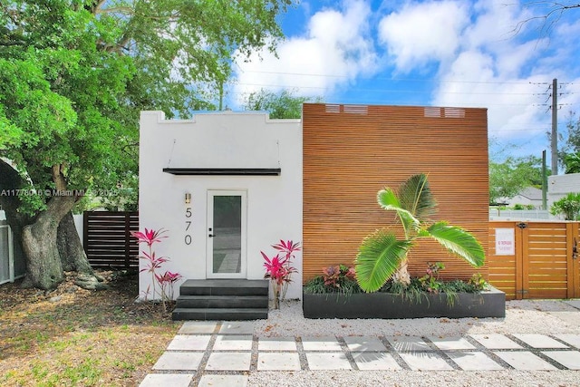 contemporary house with stucco siding and fence