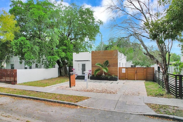 view of front of property with stucco siding, a gate, and a fenced front yard