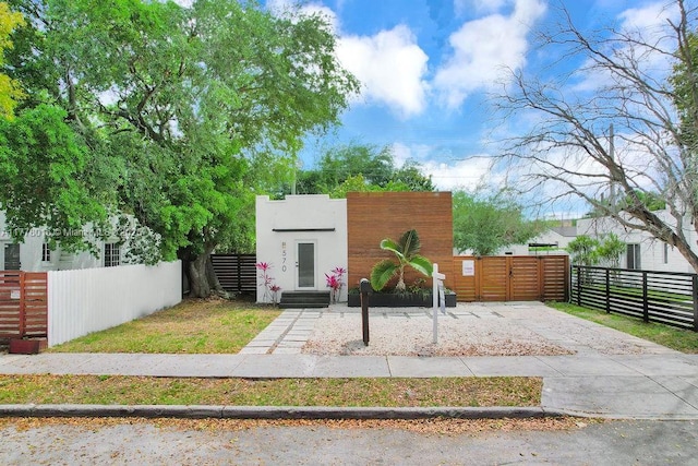 view of front of property with stucco siding, a gate, a fenced front yard, and entry steps