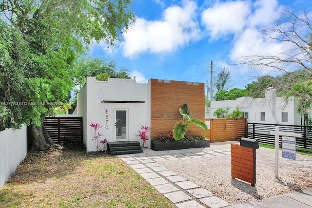 exterior space with stucco siding, a gate, and fence