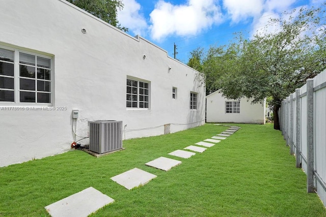 view of yard with central AC unit and a fenced backyard